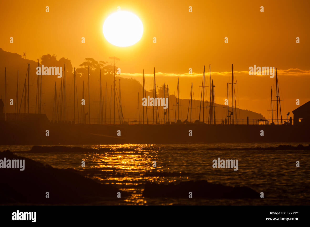 Silhouette der Masten der Schiffe gegen Sonnenuntergang über den Hafen von Gordons Bay in der Provinz Westkap in Südafrika Stockfoto