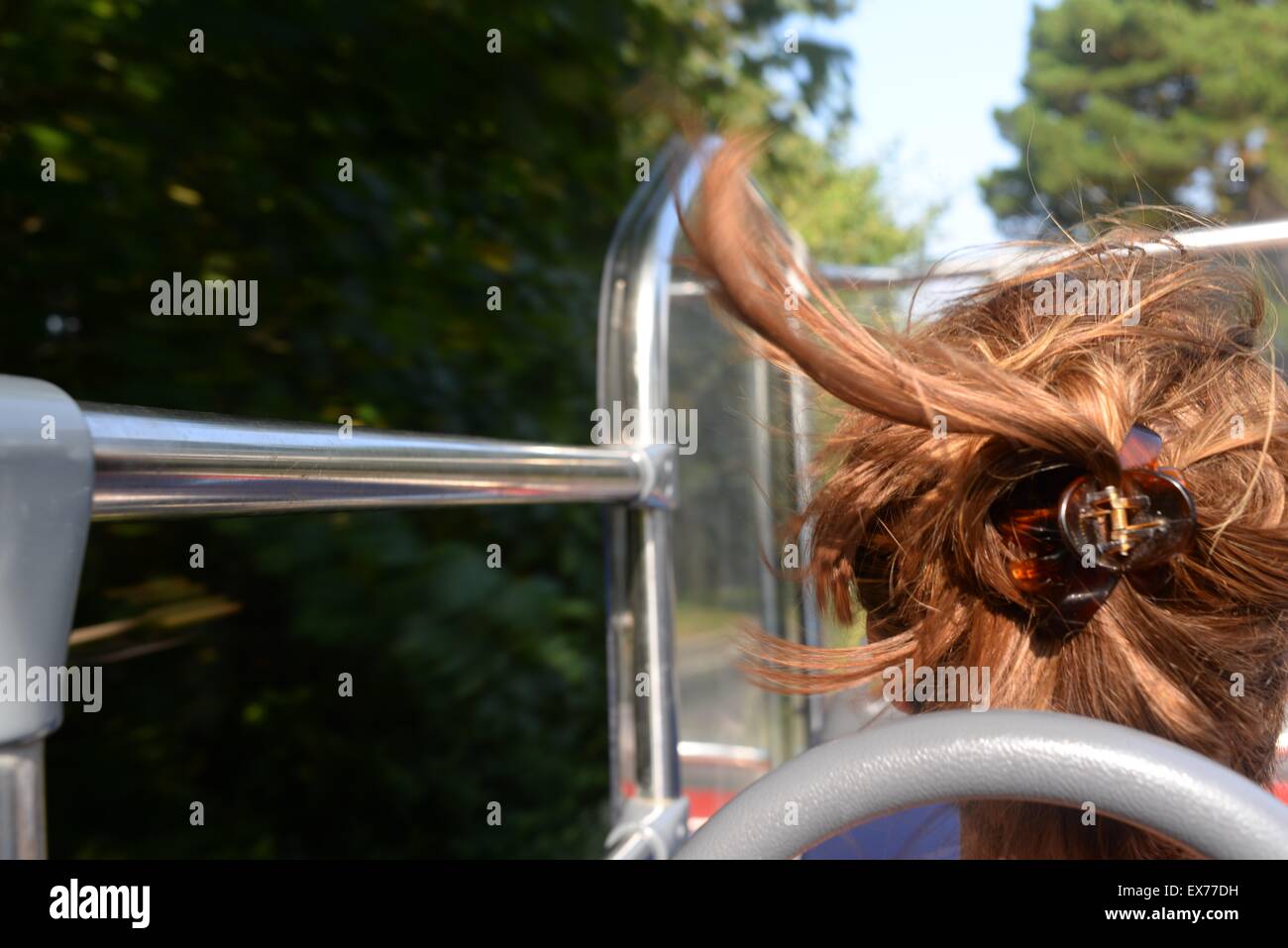 Frau mit im Wind wehenden Haaren auf einem offenen Oberteil Bustour Stockfoto