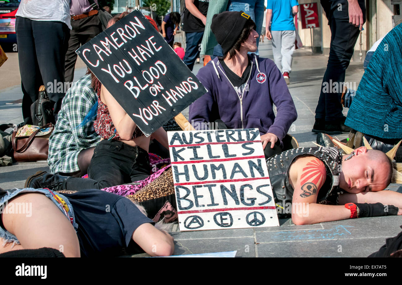 Exeter, Devon, UK. 8. Juli 2015. Demonstranten lag auf dem Boden mit Plakaten, die sagt "Sparmaßnahmen Kils Mensch" und "Cameron Sie haben Blut an Ihren Händen" an der Exeter Budget Aktionstag #AusterityKills in Exeter City Centre am 8. Juli 2015 in Bedford Square, Exeter, UK Credit: Clive Chilvers/Alamy Live News Stockfoto