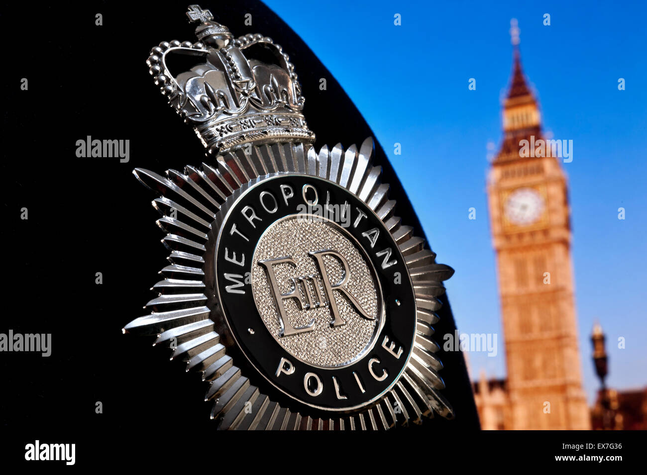 Metropolitan Police Helm und Abzeichen aus nächster Nähe mit dem Regierungssitz des Power Law Houses of Parliament Tower und Big Ben Westminster London Concept UK. Stockfoto