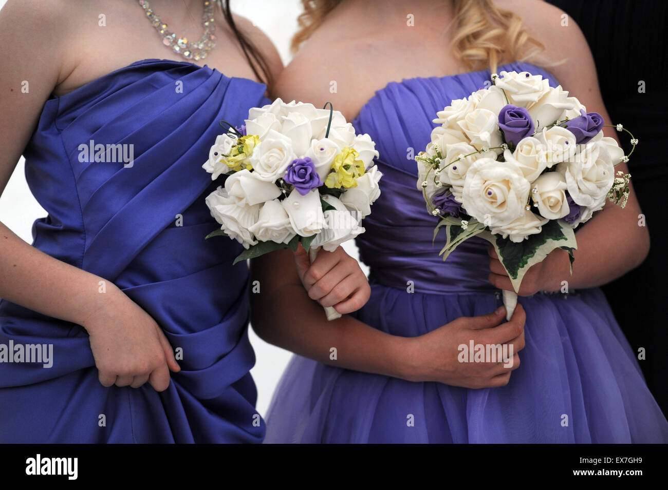 Pontypridd, Wales, UK. Hautnah auf 2 Brautjungfern in lila satin Kleider mit weißen Rosensträuße. © Becky Matthews Stockfoto