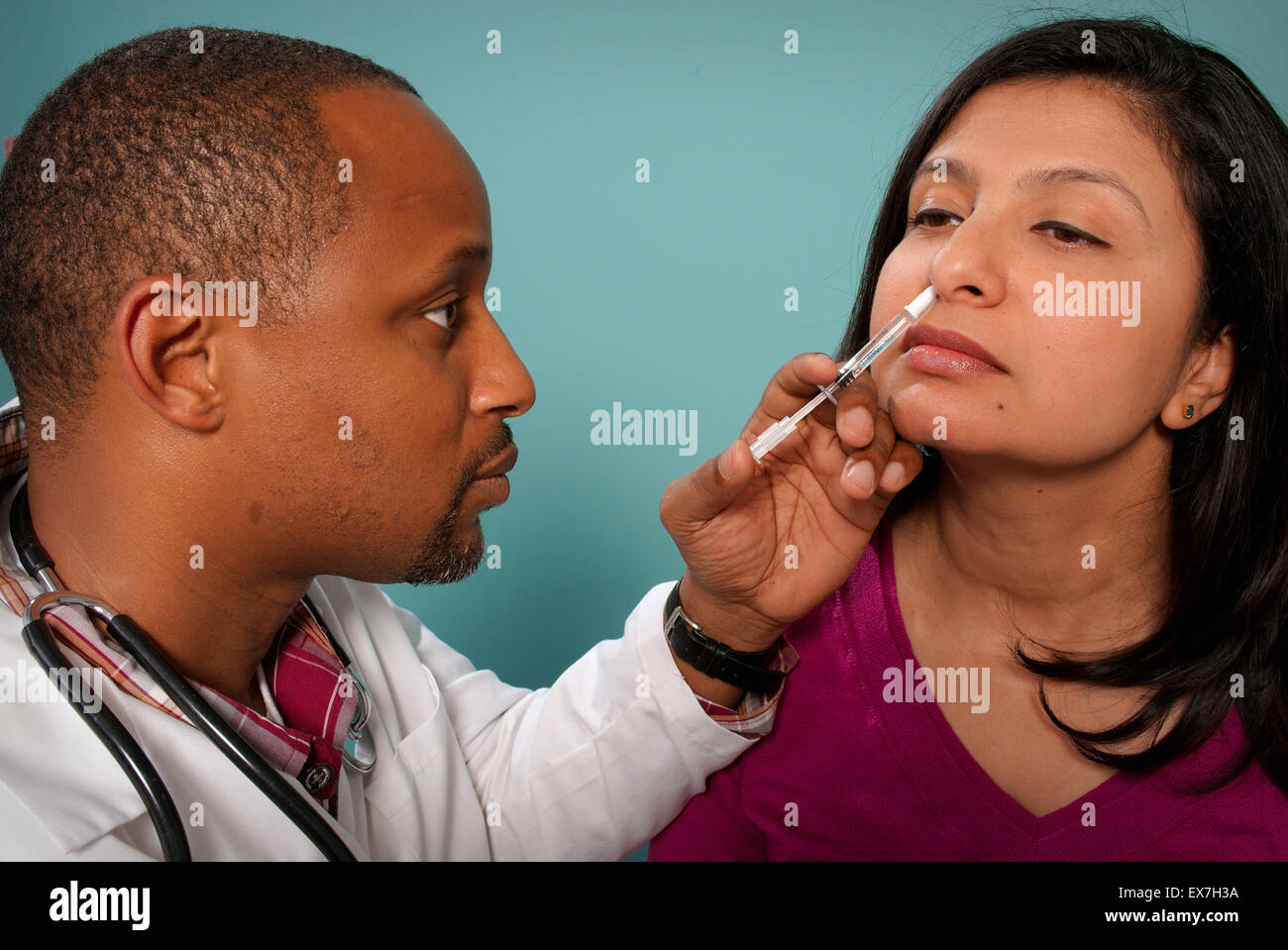 Mitarbeiter Verwaltung einen intranasale Influenza-Impfstoff im Nasenloch des Patienten. Stockfoto
