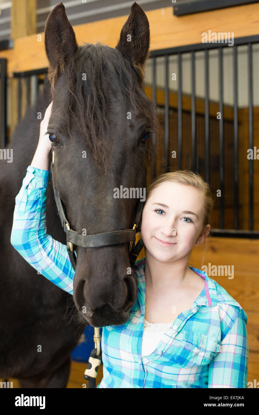 Teenager-Mädchen Reinigung Pferd HUF Stockfoto
