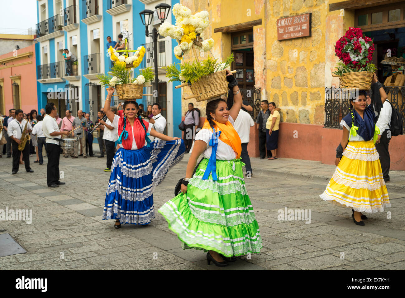 Frauen in traditionellen Kostümen tanzen und Durchführung Blumenkörbe auf ihren Köpfen führt eine Parade auf einem Festival in Oaxaca, Mexiko Stockfoto