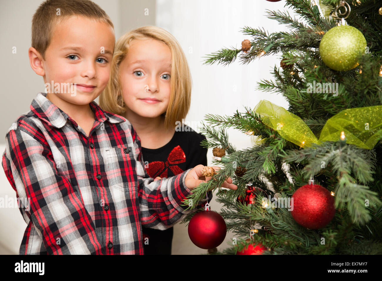Bruder (6-7) und Schwester (6-7) dekorieren Weihnachtsbaum Stockfoto