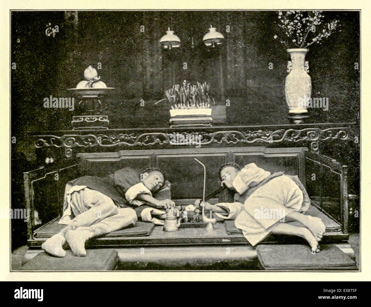 Wohlhabende Opium Raucher in der oberen Klasse Opium Höhle in der Stadt Shanghai, China ca. 1908. Im Vordergrund Teekanne und Tabak. Foto: original Foto: Mencarini 1908 veröffentlicht. Stockfoto