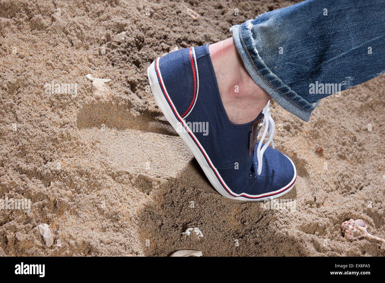 Mann Männer Schuhe sand Jeans Denim Fuß drucken schließen Studio Objekt Spitzen Stein Schale Meer Strand Sommer Rest Urlaub Süden Stockfoto