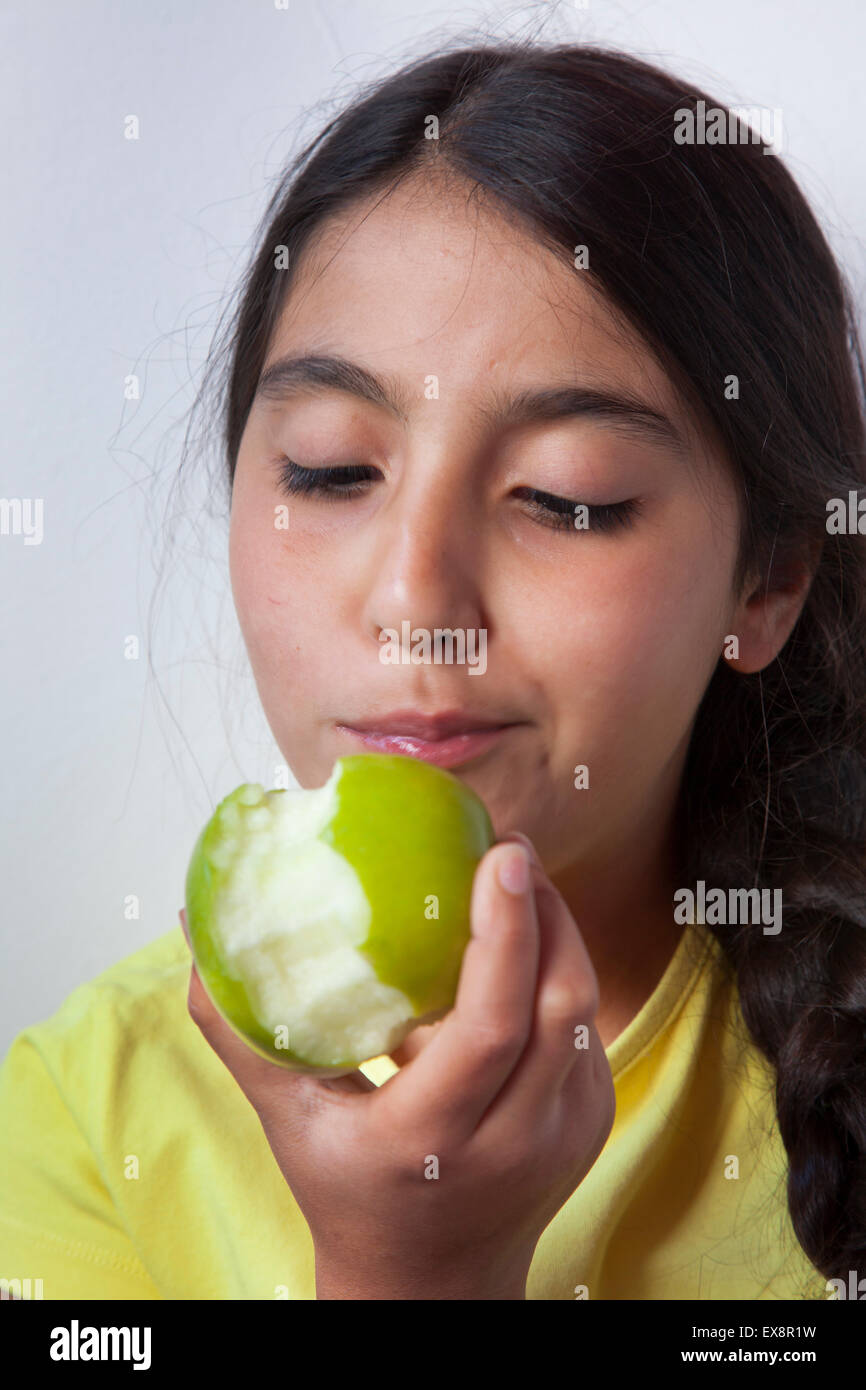 Teenager-Mädchen einen grünen Apfel zu essen Stockfoto