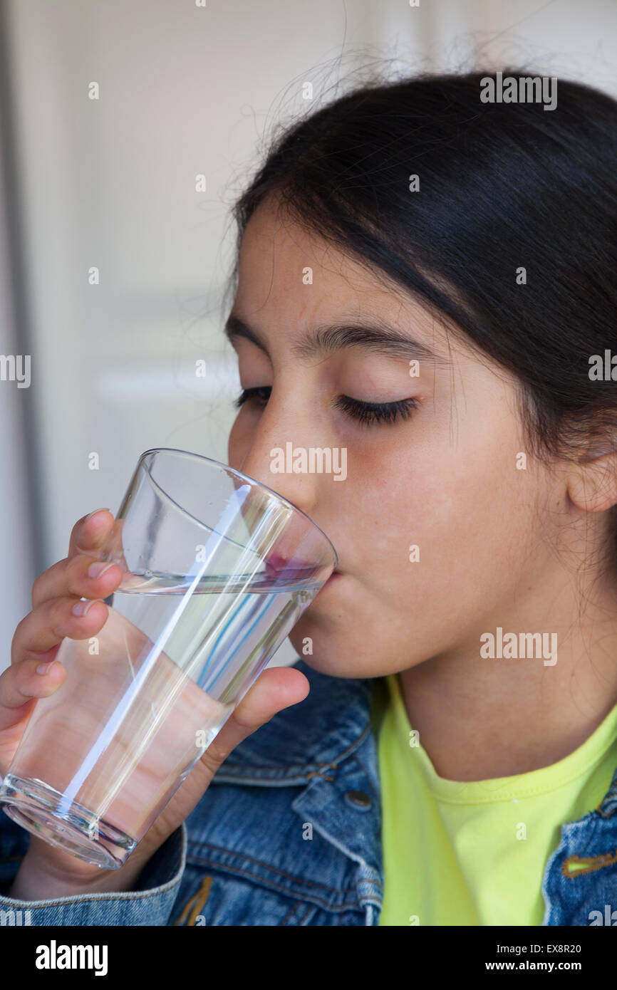 Teenager-Mädchen trinken ein Glas Wasser Stockfoto
