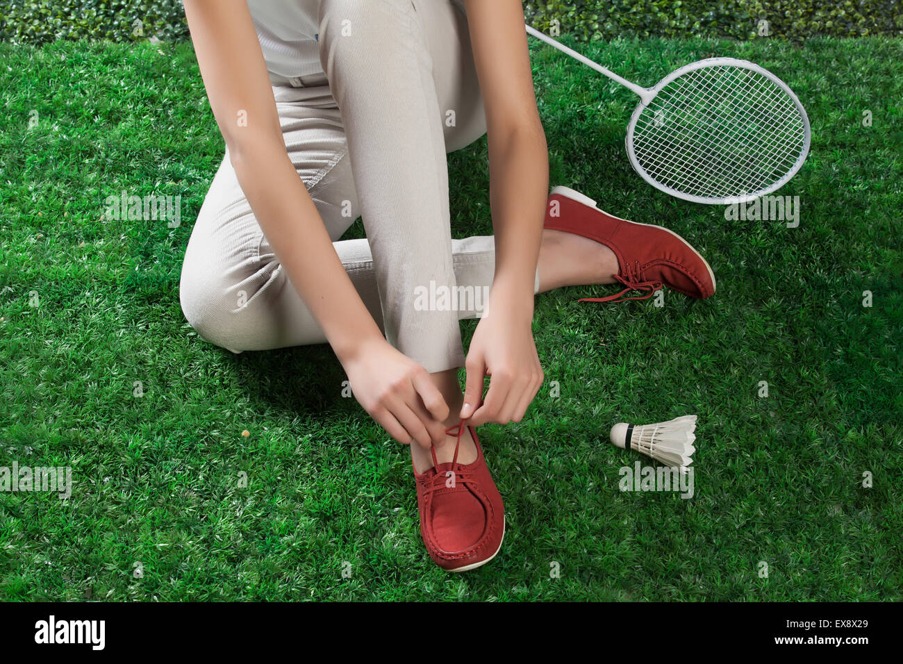Frau Frauen weibliche Weiblichkeit Badminton Bein Schläger Federball Grasgrün Sport Natur Körper Teil schließen sich Outdoor-Schuhe Stockfoto