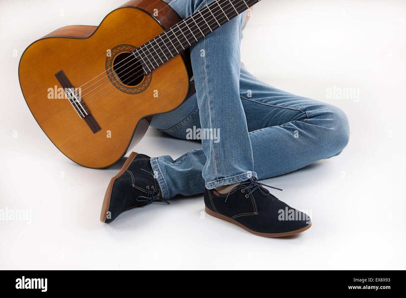 Mann Männer männlich Studio Jeans Denim Objekt Hintergrund Gitarre spielen Körper Teil Musik Instrument isolierte Gruppe Zeichenfolge Kunst Schuhe Hals Stockfoto