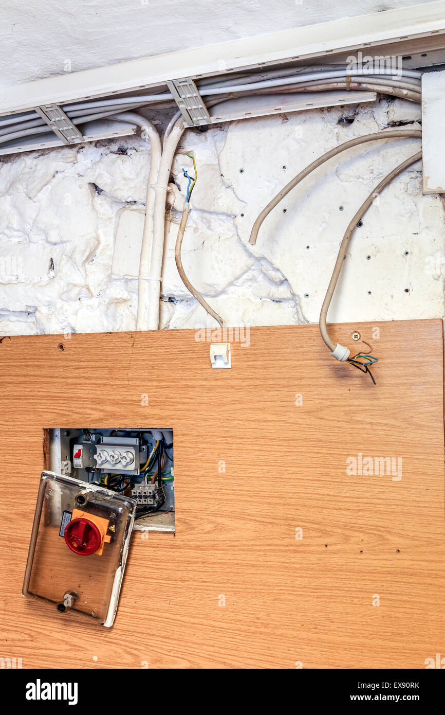 Locker und enthaltene Netzkabel und offener Schalter in einem verlassenen Gebäude Stockfoto