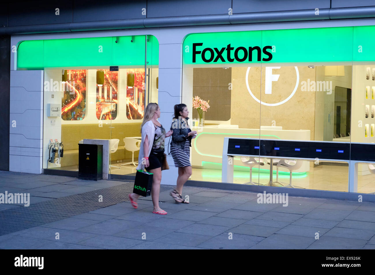 Zwei Frauen gehen vorbei an Foxtons Immobilienmakler in Shepherds Bush Stockfoto