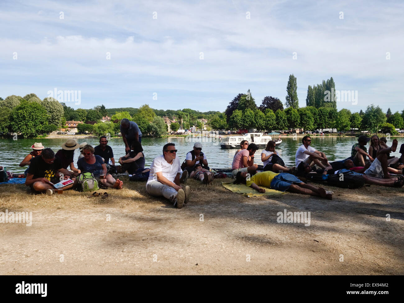 Besucher genießen und entspannen, sitzen am Seineufer, während Django Reinhardt Festival Samois-Sur-Seine, Frankreich. Stockfoto