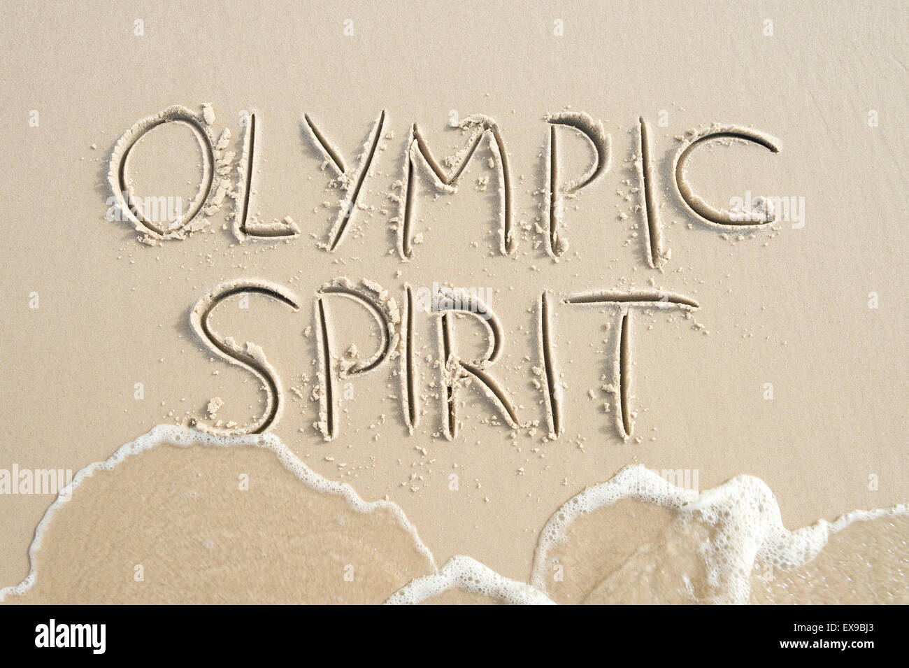 Einfache Olympischen Geist Botschaft handschriftlich in sauberen Text auf glatte Sandstrand mit Spritzwasser Wellen in Rio De Janeiro Brasilien Stockfoto