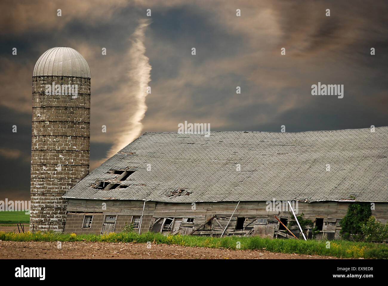 Alte Scheune und Silo mit Sonnenuntergang Himmel. Stockfoto