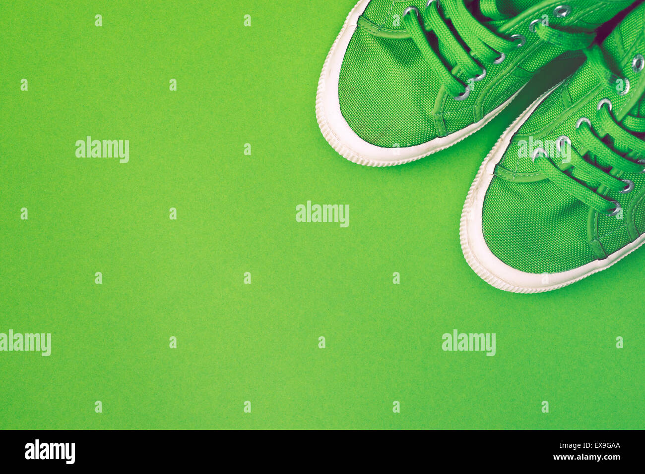 grüne Turnschuhe über saubere grüne Hintergrund mit viel Leerraum Stockfoto