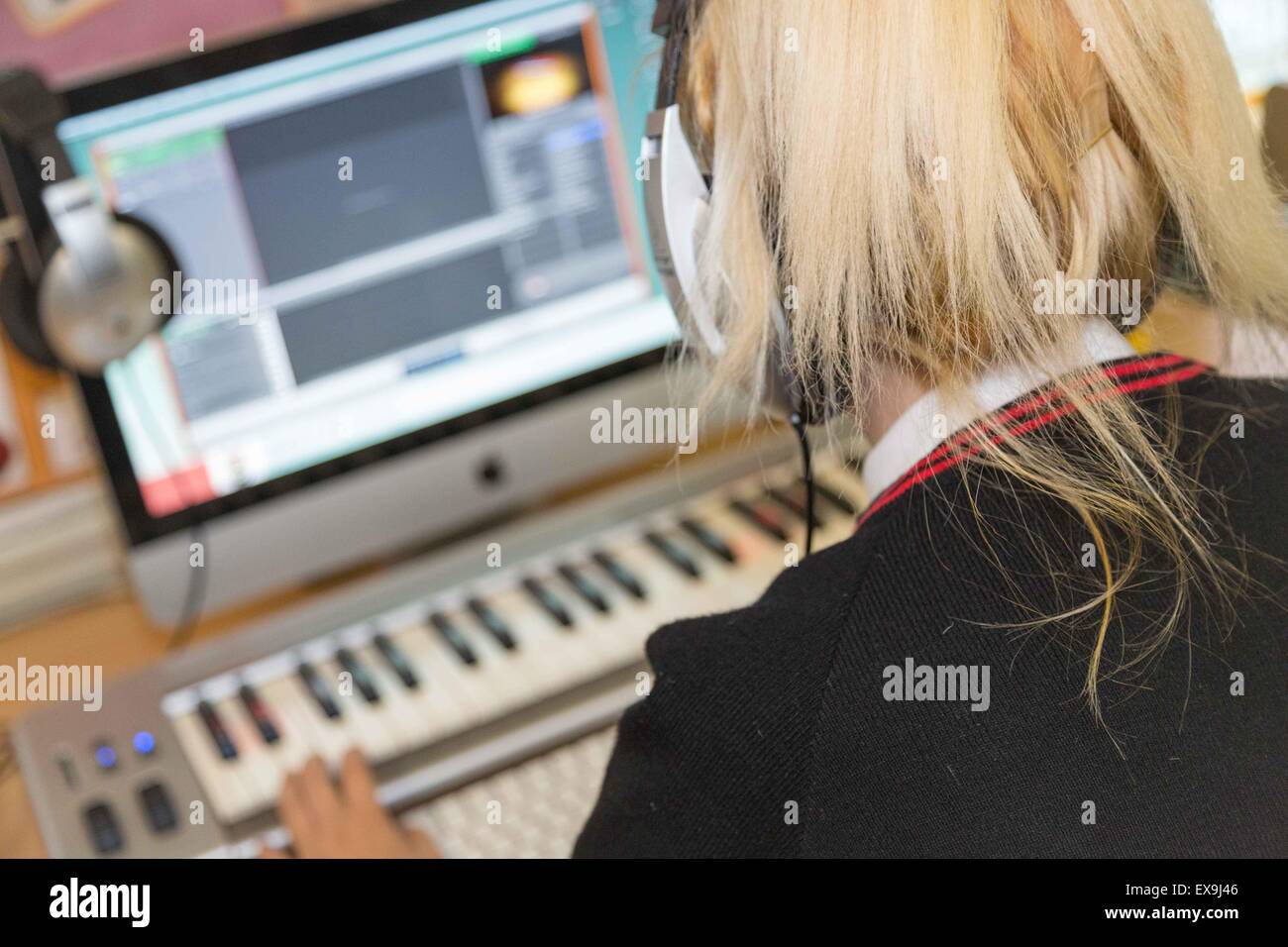 Schülerinnen und Schüler in Uniform, mit Musik-Software und Ausrüstung in Lektion Stockfoto