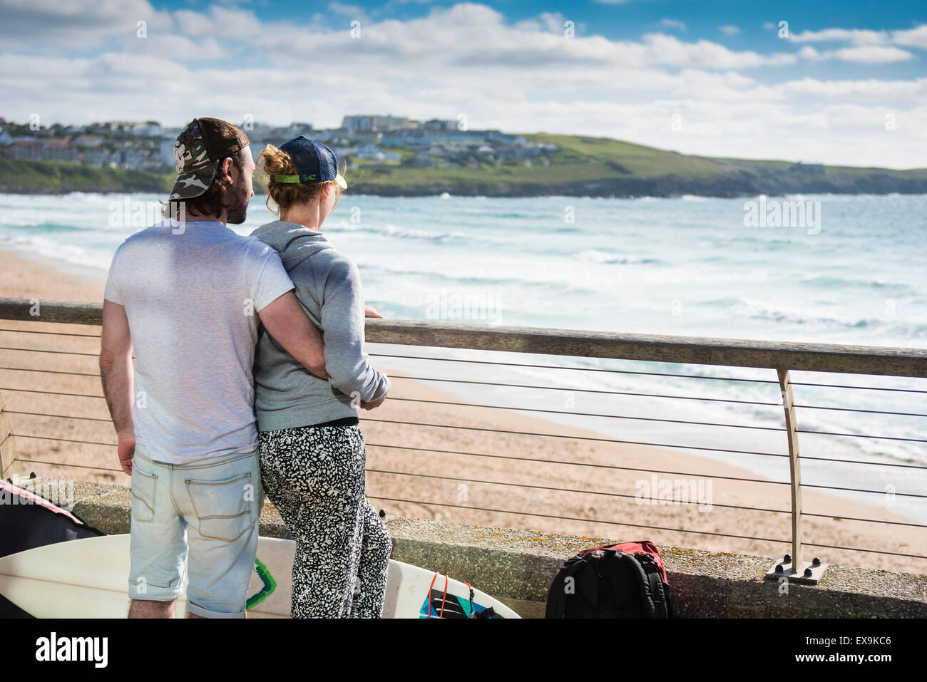 Ein paar umarmen, wie sie auf einem Balkon mit Blick auf Fistral Strand in Newquay, Cornwall stehen. Stockfoto