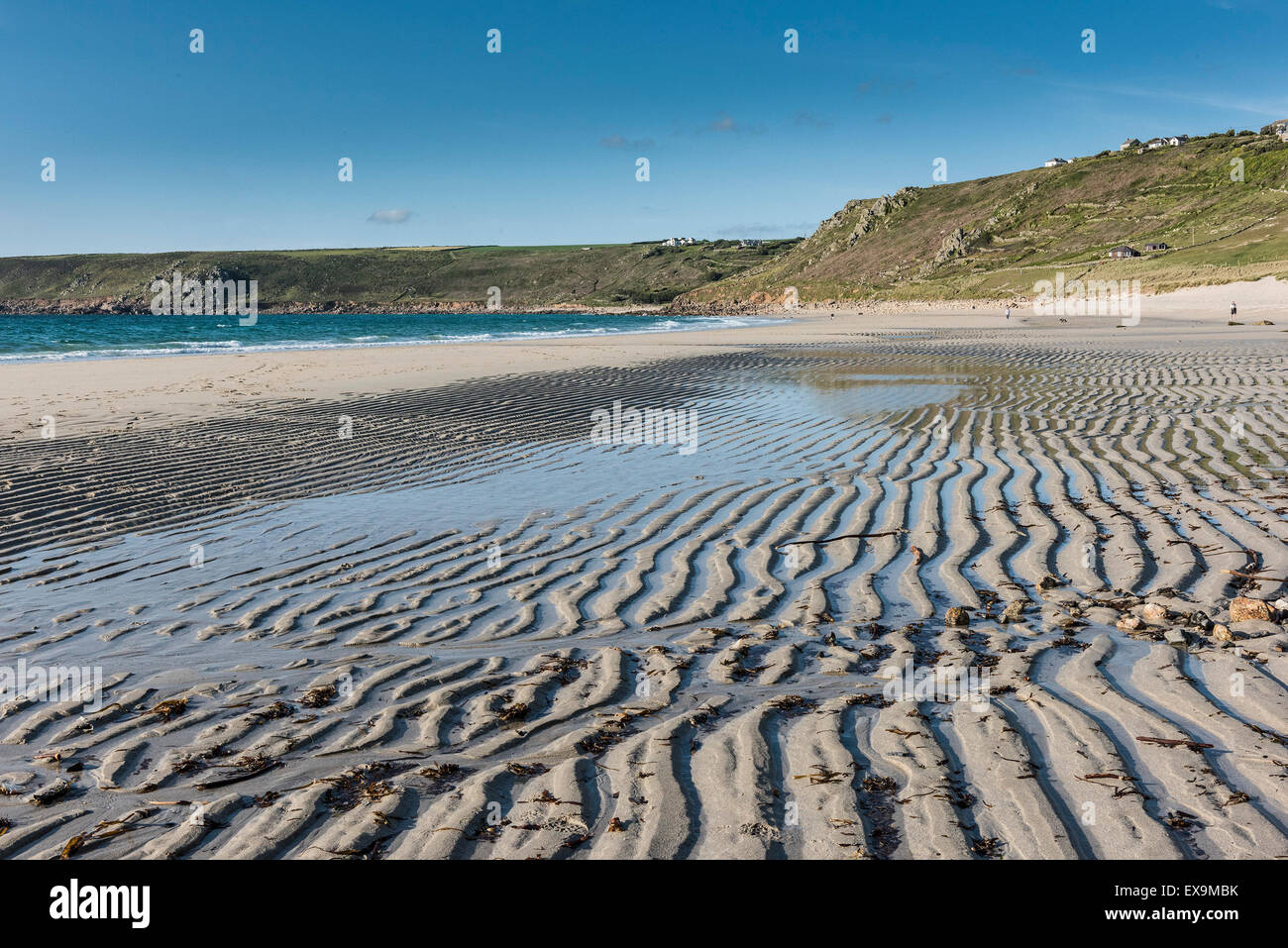 Sand, Wellen am Strand von Sennen in Cornwall. Stockfoto
