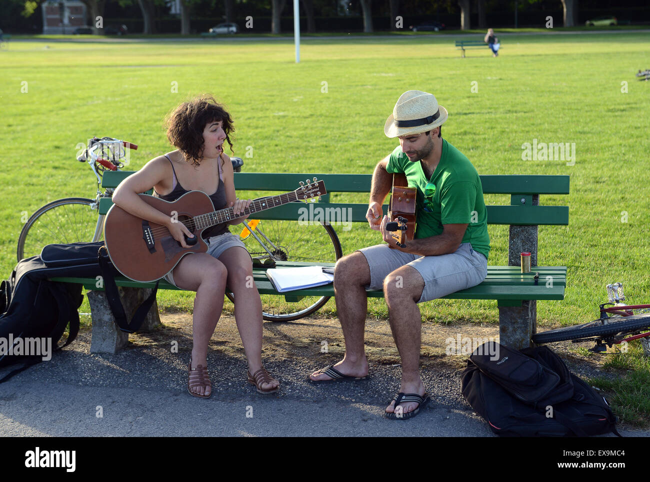 Paar Duett singen & spielen Gitarre Gitarren auf öffentlichen Parkbank in Annecy, Frankreich Stockfoto