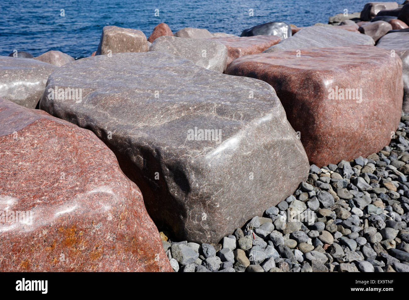 Glänzend polierte Felsen Kunstwerk Fjoruverk auf der Küste Wellenbrecher auf Saebraut Island Stockfoto