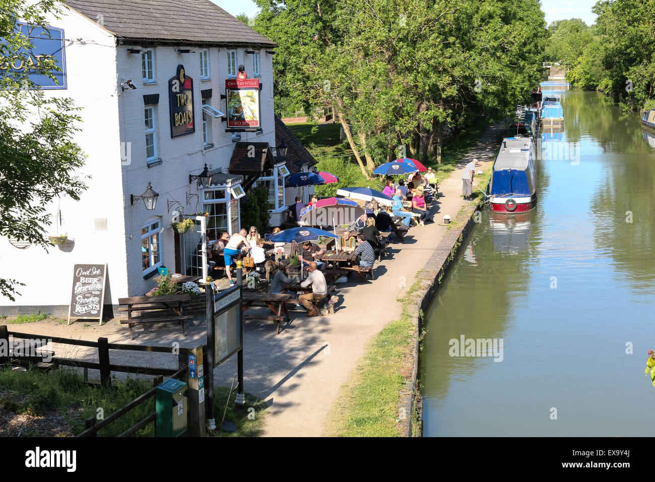 Eaating al Fresco in einem Canalside Pub in der englischen Landschaft.  Die beiden Boote auf lange Itchington ist ein beliebtes Pub. Stockfoto