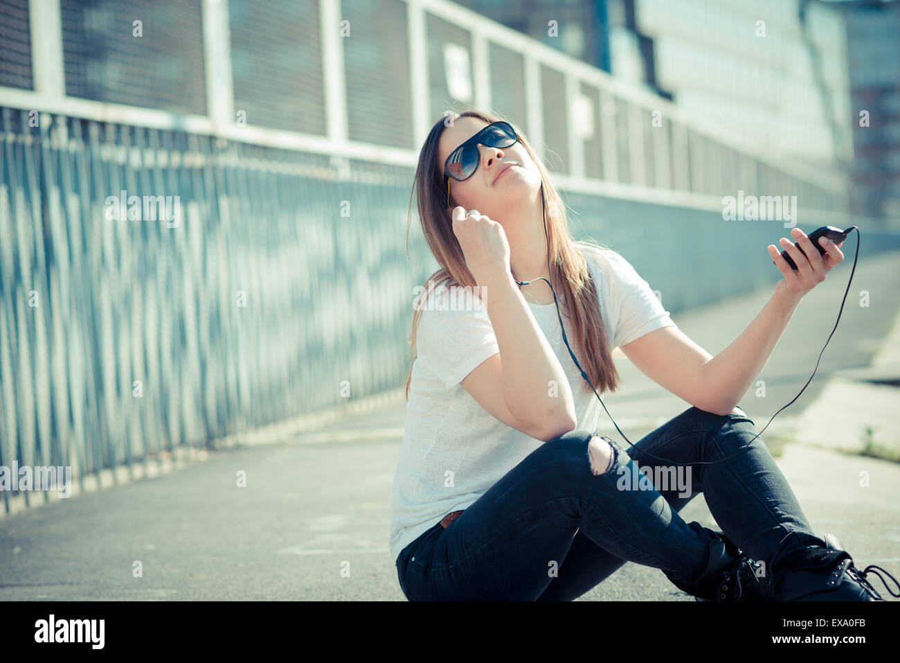 junge schöne Frau Musik hören in der Stadt Stockfoto