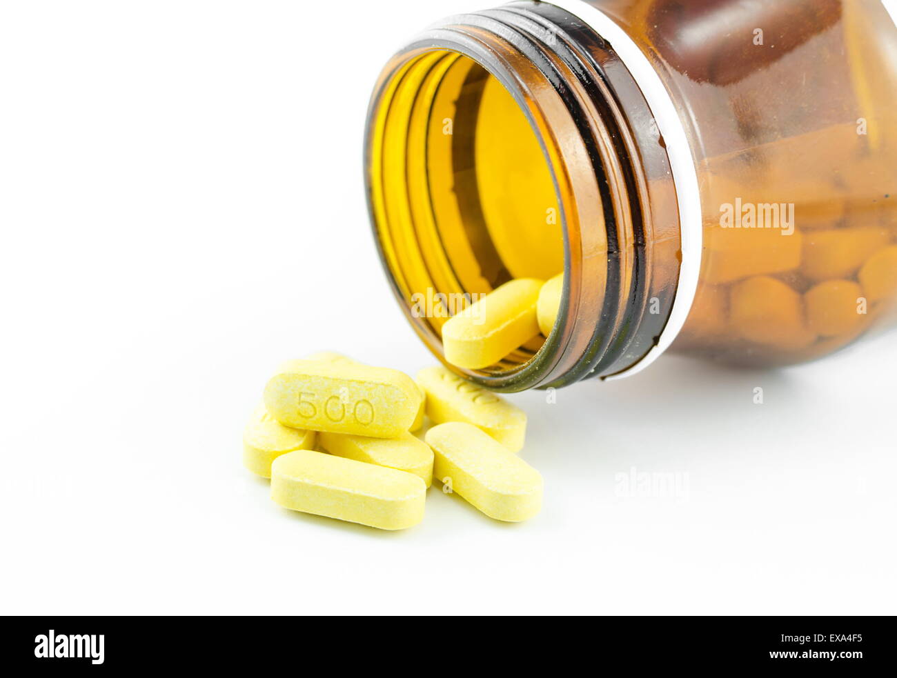Die Strömung von Pillen aus einer braunen Flasche. Stockfoto