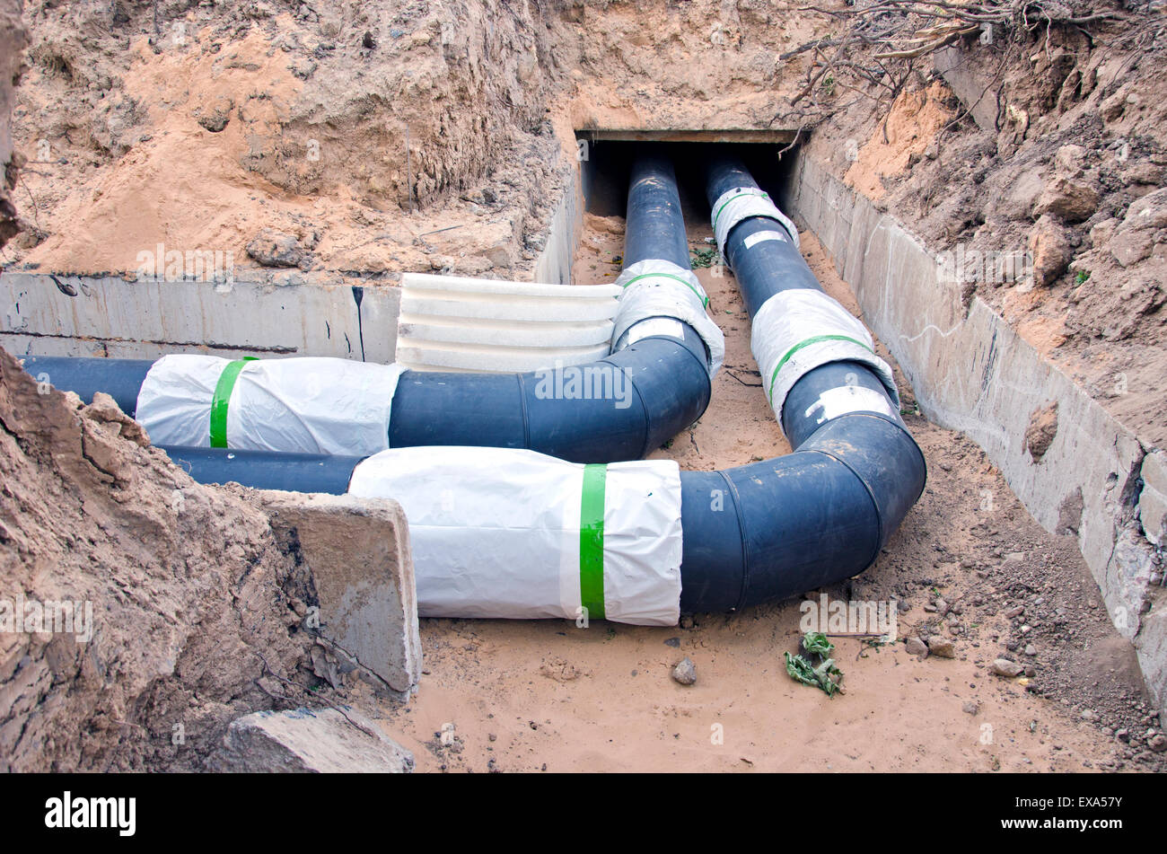 moderne Kunststofftechnik schwarz Heizungsrohre im Graben in der Nähe von Stadthaus Stockfoto