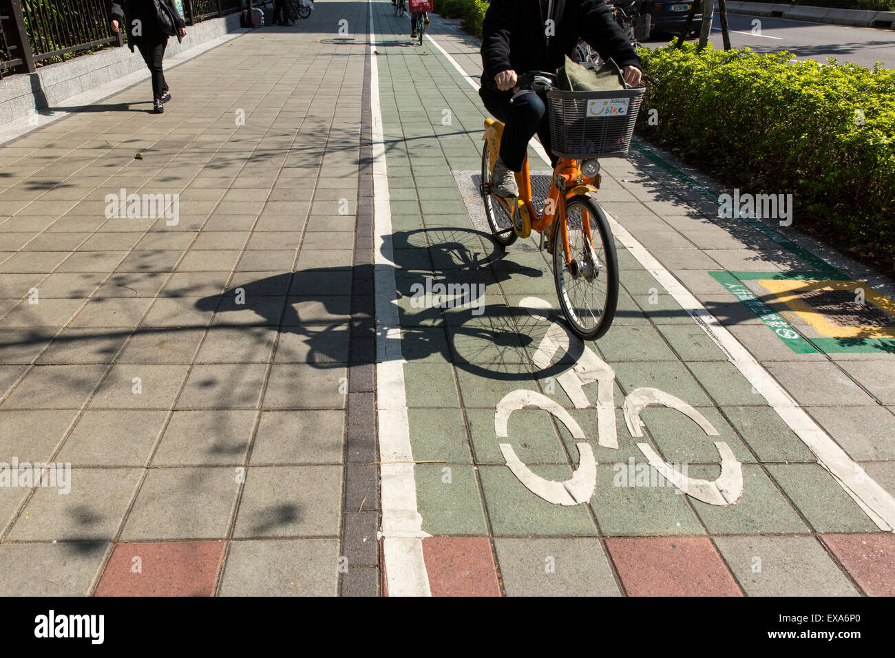 Asien, Taiwan, Taipei, Schatten des Reiters hausieren Fahrrad in der Nähe von Dongmen Markt entlang Xin Yi Road an sonnigen Wintermorgen Stockfoto