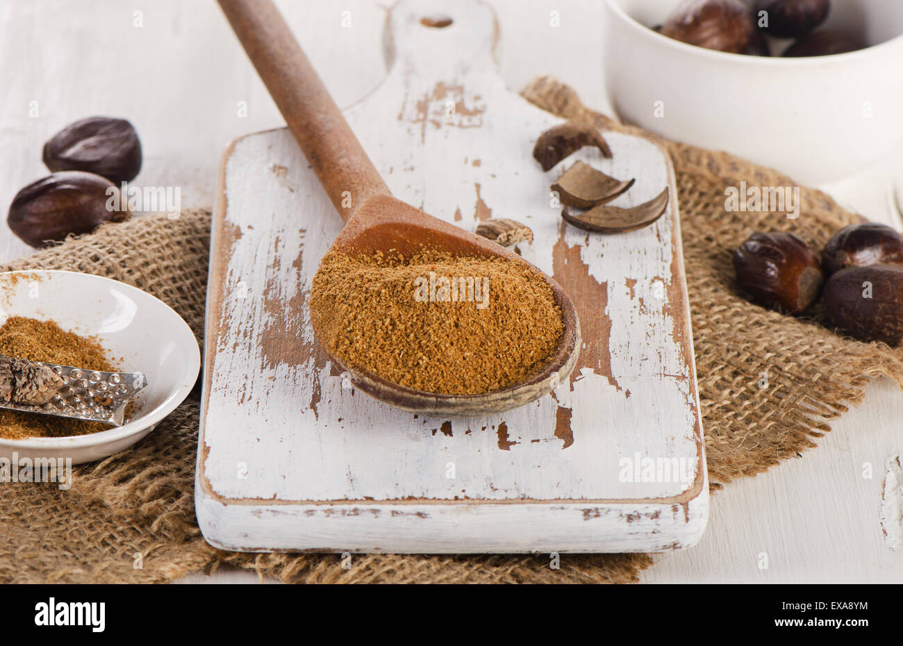 Rohe organische gemahlener Muskatnuss auf einem weißen Holzbrett. Selektiven Fokus Stockfoto