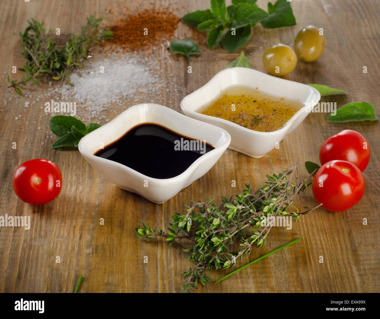 Dressing Zutaten auf einem rustikalen Hintergrund. Olivenöl, Balsamico-Essig, Kräuter, Salz und Pfeffer. Selektiven Fokus Stockfoto