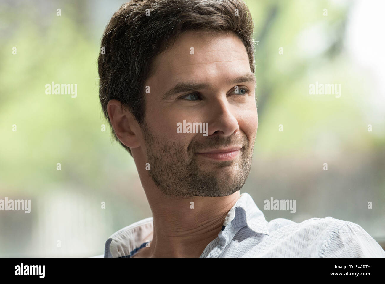 Mann lächelt zufrieden, Porträt Stockfoto