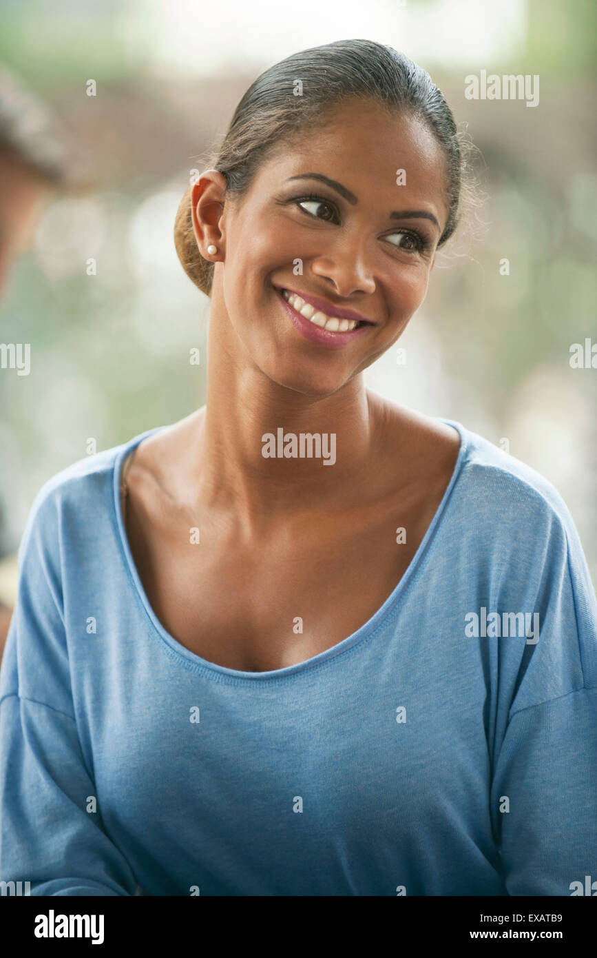 Frau lächelnd mit Kopf gekippt, Porträt Stockfoto