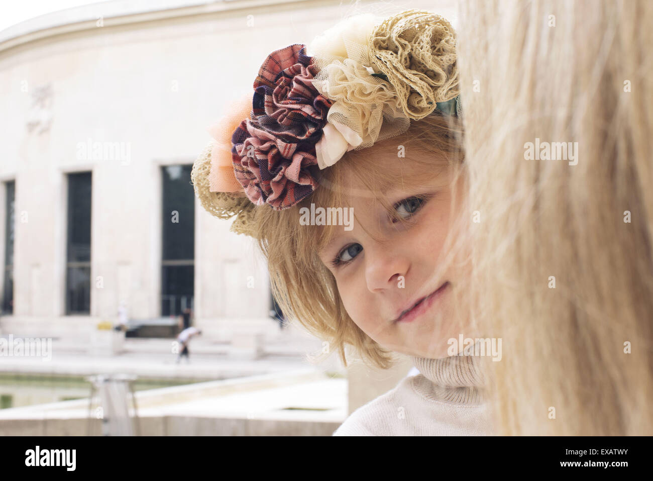 Kleines Mädchen spähen um Mutters Kopf, Porträt Stockfoto