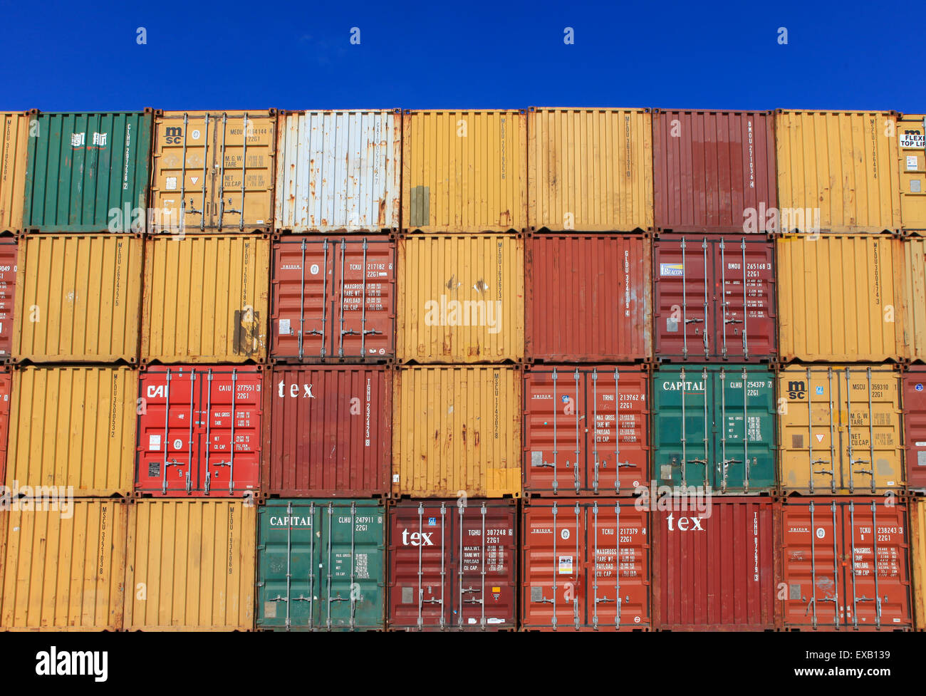 Verschiedene Marken und Farben der See-Container gestapelt Stockfoto