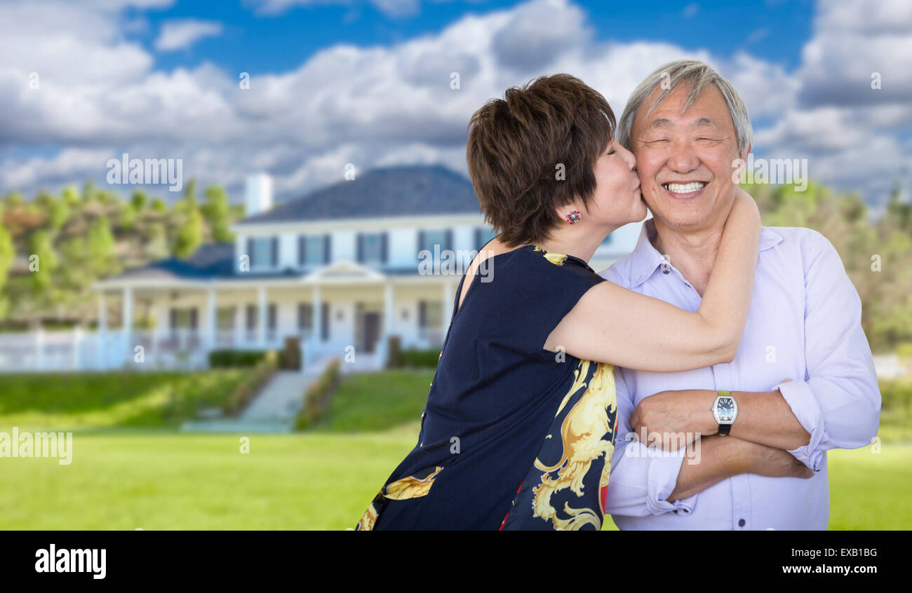 Attraktive liebevolle Senior chinesisches Ehepaar vor schönen Haus. Stockfoto