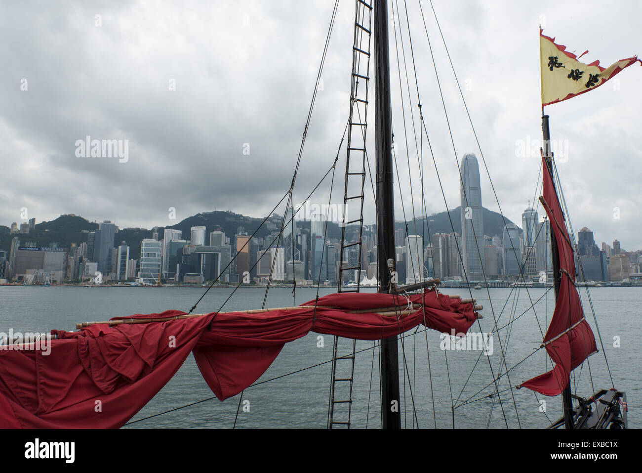 Segelboot mit roten Segeln im Hafen von Hong Kong Stockfoto