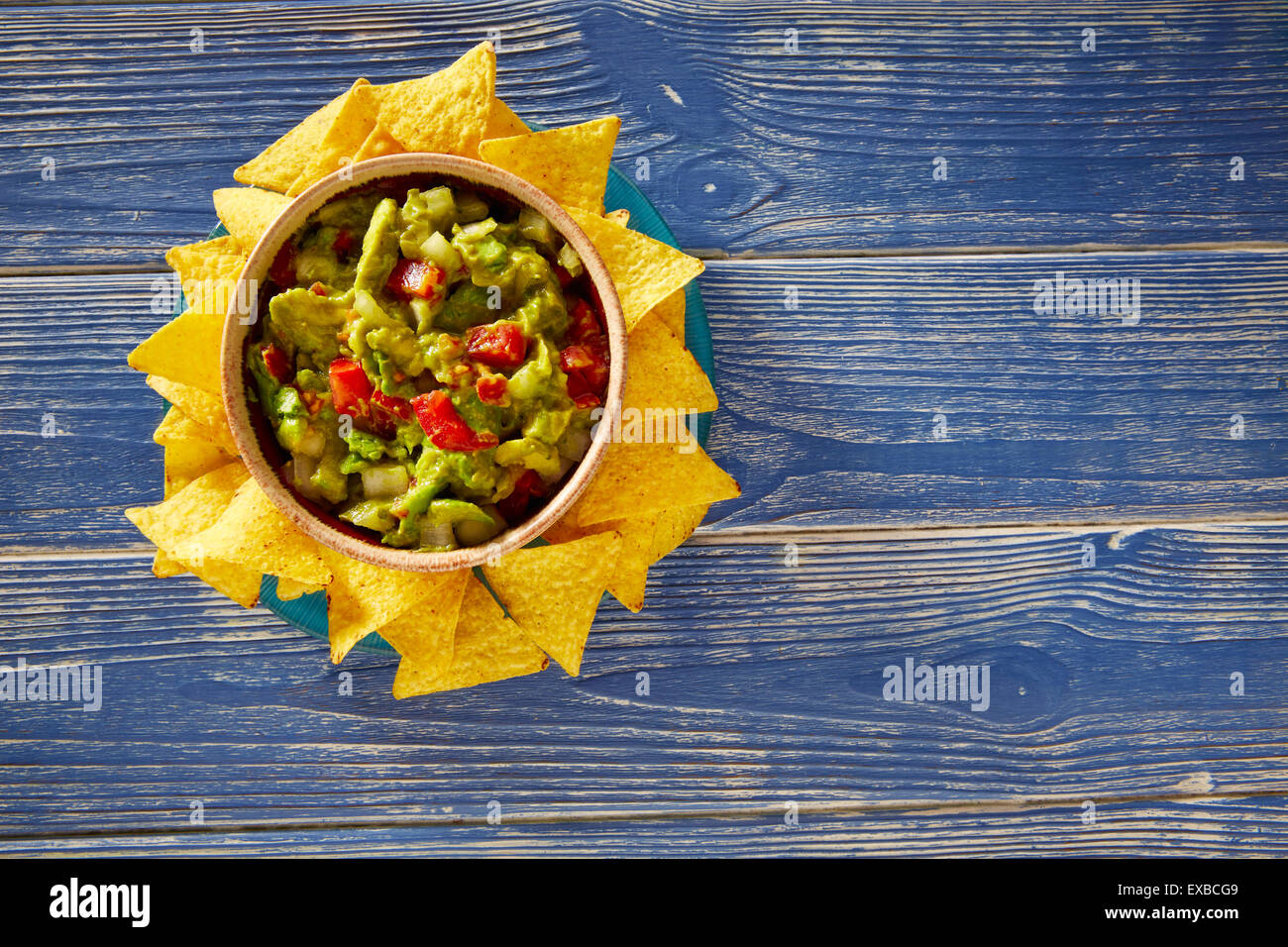 Guacamole mit Avocado Tomaten mexikanisches Essen auf blau Holz Stockfoto