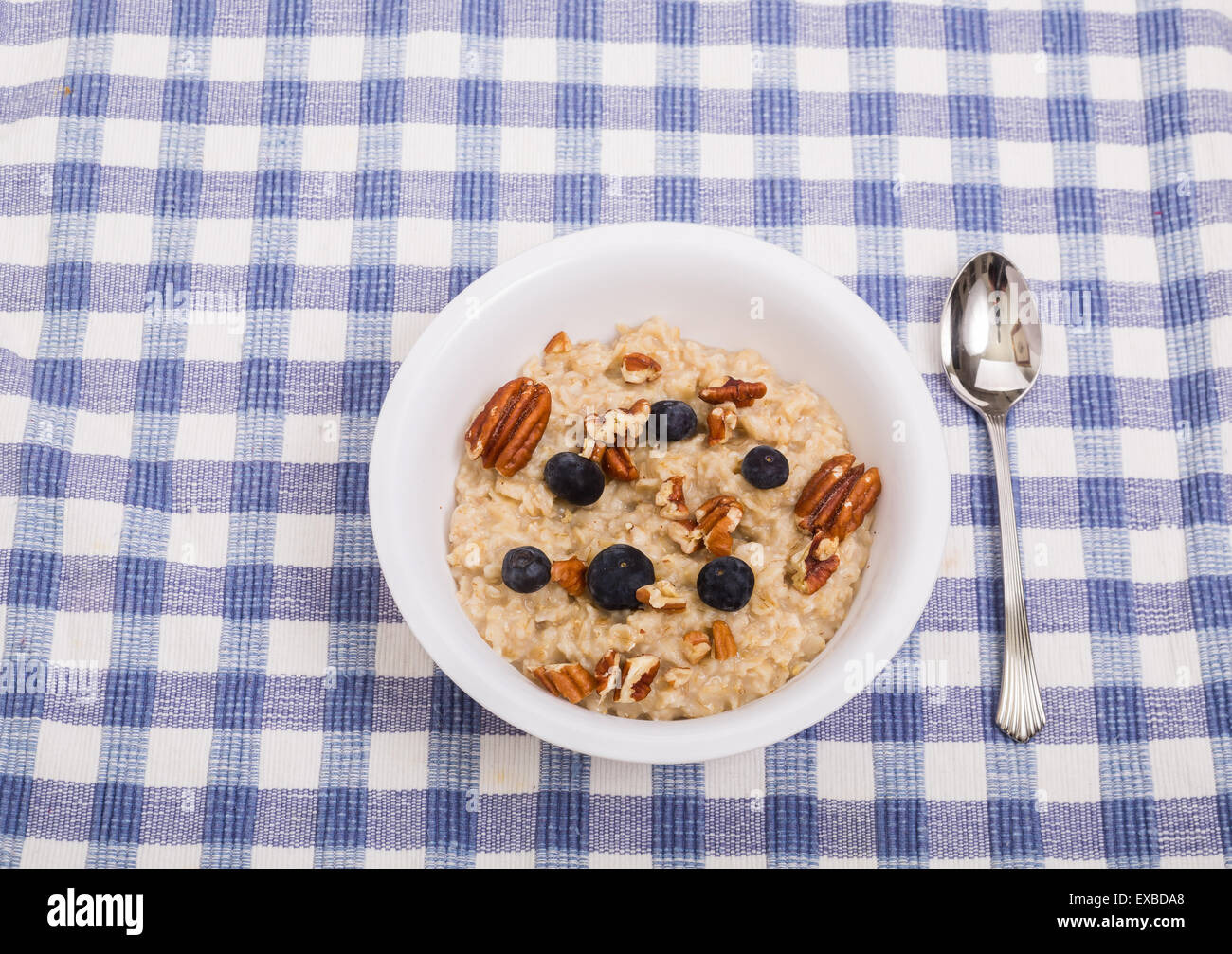 Eine Schüssel Haferflocken mit Obst auf einer blauen Tischset Stockfoto