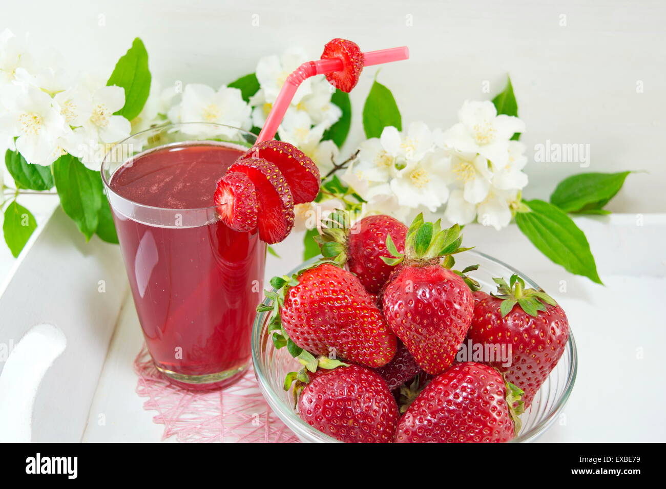 Erdbeersaft und frischen Erdbeeren serviert auf die Blumen dekorierten Teller Stockfoto