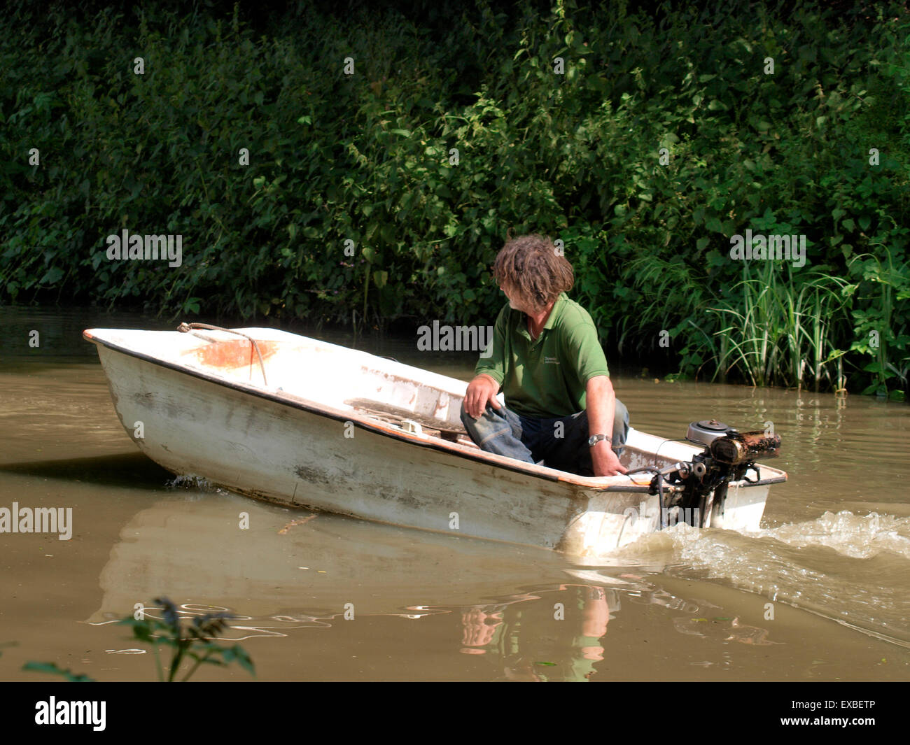 Mann reitet eine alte Jolle auf dem Kennet & Avon Kanal in der Nähe von Bradford on Avon, Wiltshire, UK Stockfoto