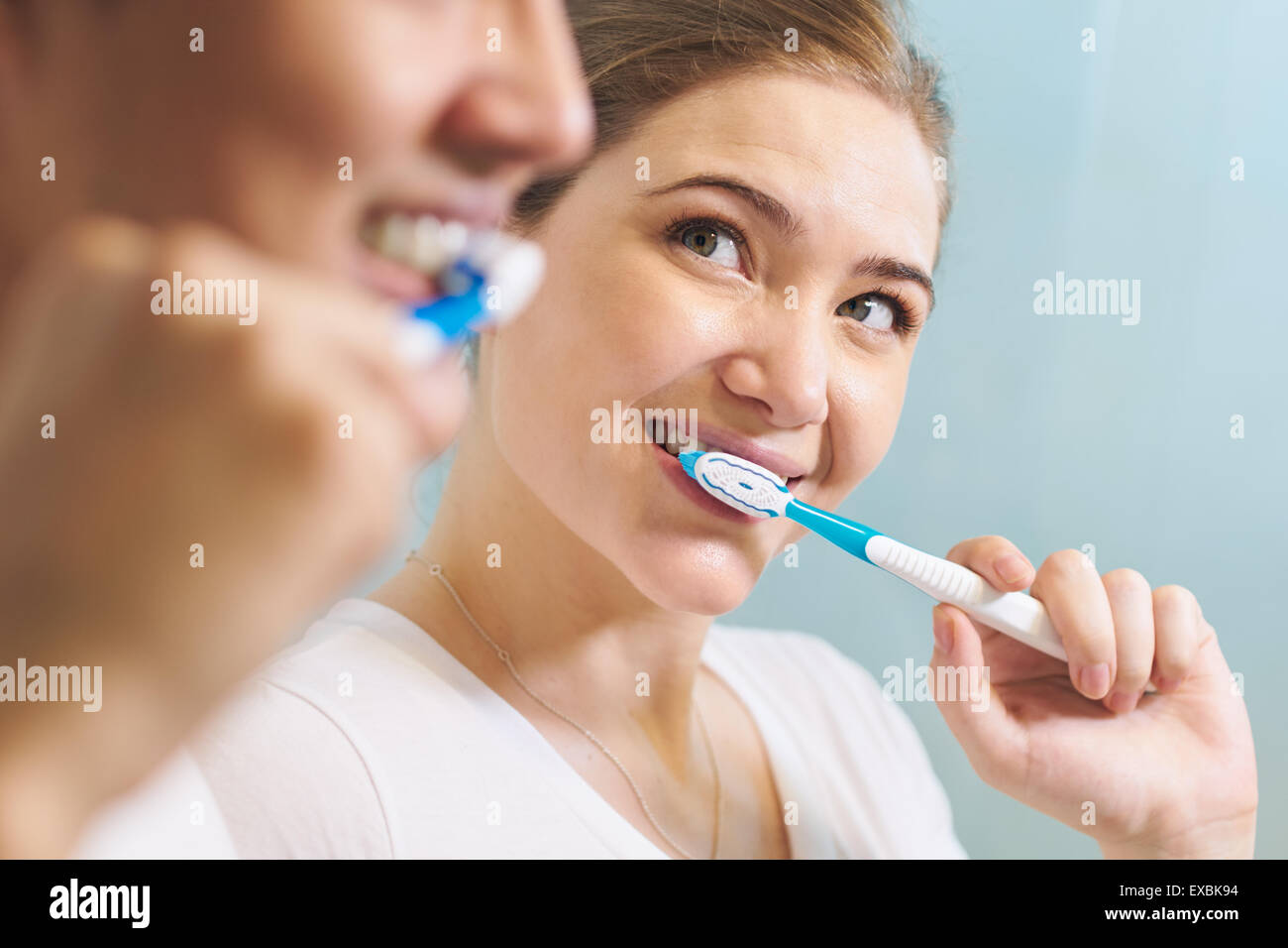Junges Paar Zusammenleben, waschen Zähne im Bad am Morgen. Die Frau schaut gerne an ihren Freund. Konzept der neu Stockfoto