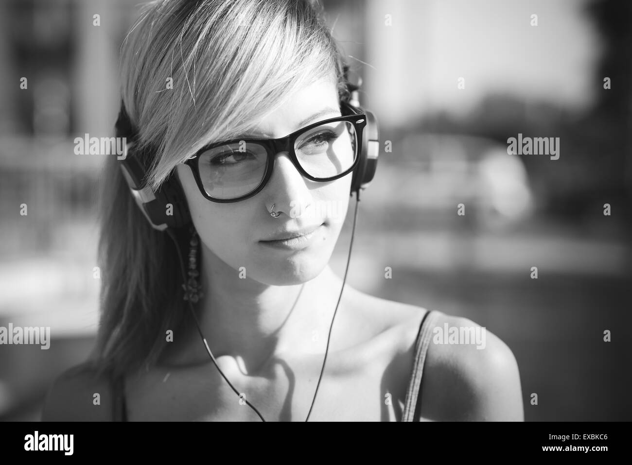 junge schöne Modell Frau Musik hören in der Stadt Stockfoto