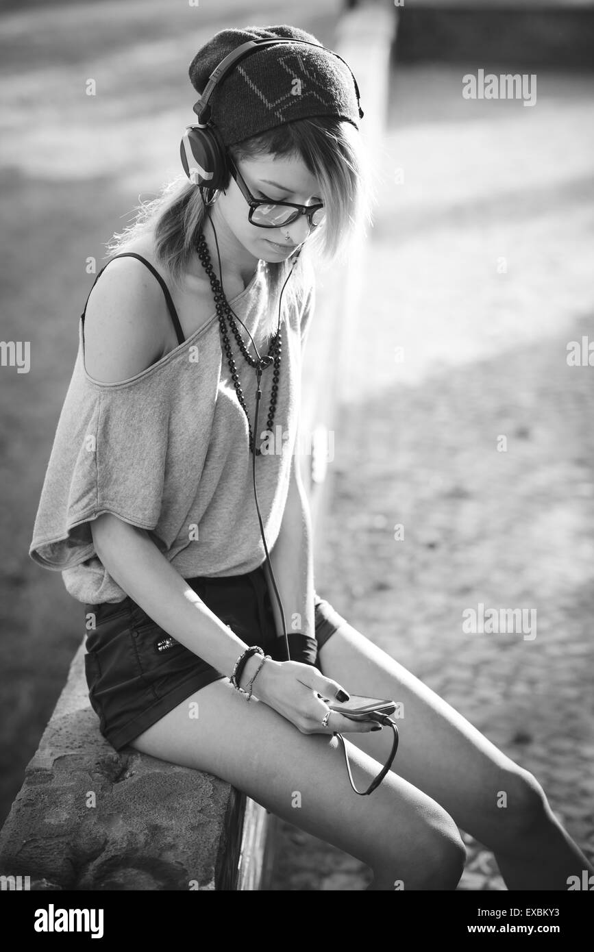 junge schöne Modell Frau Musik hören in der Stadt Stockfoto