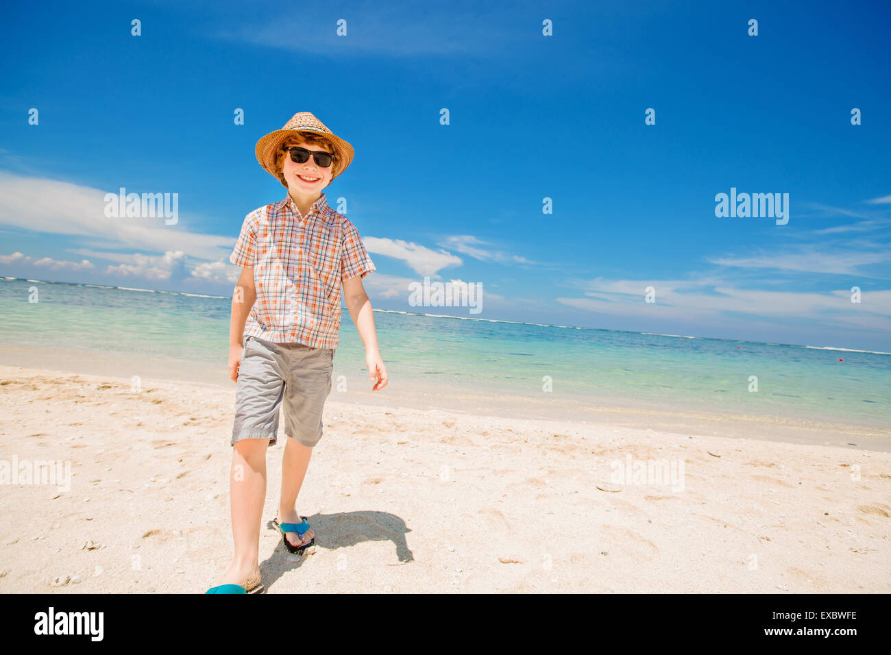 Glückliches Kind Junge im Sommer Hut und Hipster Sonnenbrille Spaziergänge am Strand und genießen Sie sonnige Zeit Stockfoto