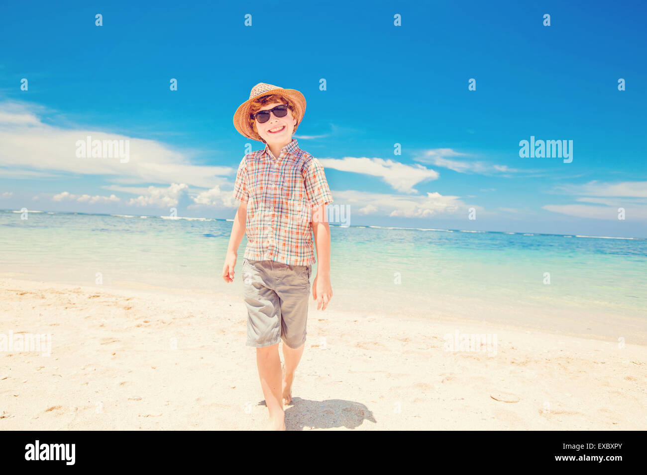 Glückliches Kind Junge im Sommer Hut und Hipster Sonnenbrille Spaziergänge am Strand und genießen Sie sonnige Zeit Stockfoto