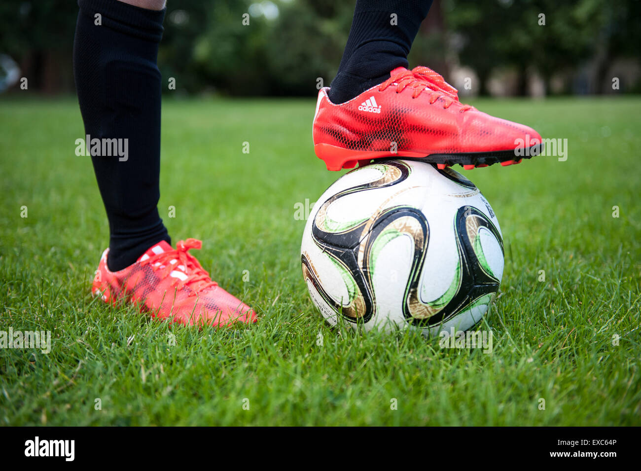 Nahaufnahme eines kleinen Jungen mit seinem Fuß auf einem Fußball Stockfoto