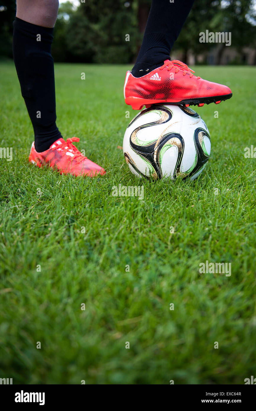 Nahaufnahme eines kleinen Jungen mit seinem Fuß auf einem Fußball Stockfoto